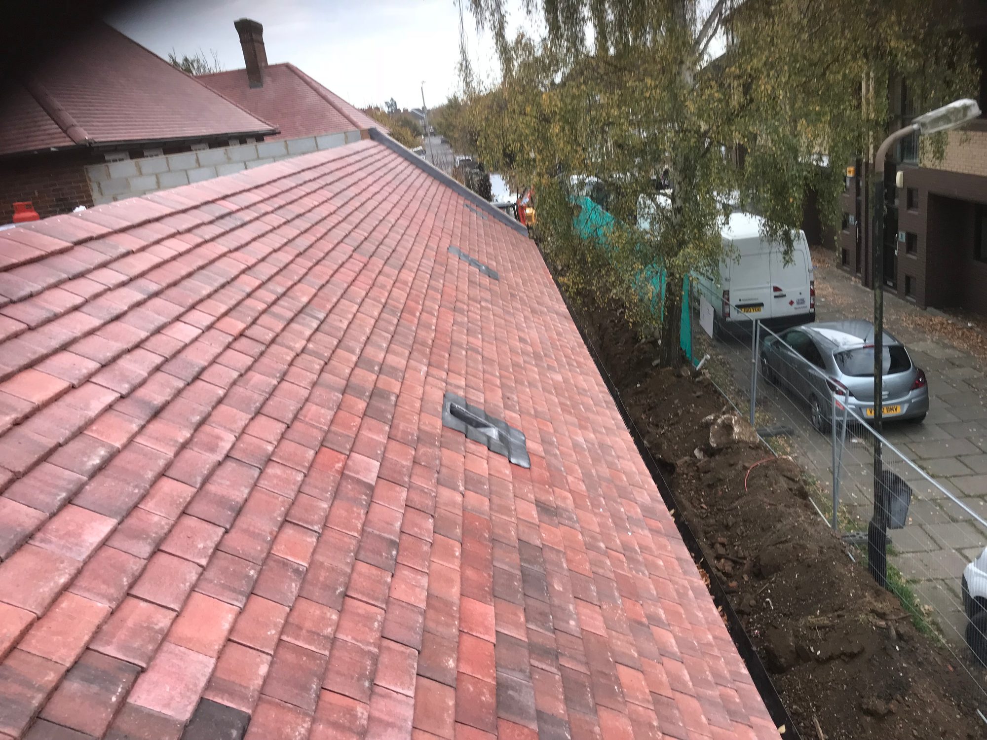 Red tiled roof showing two bespoke lead roof outlet details set within the tiled surface
