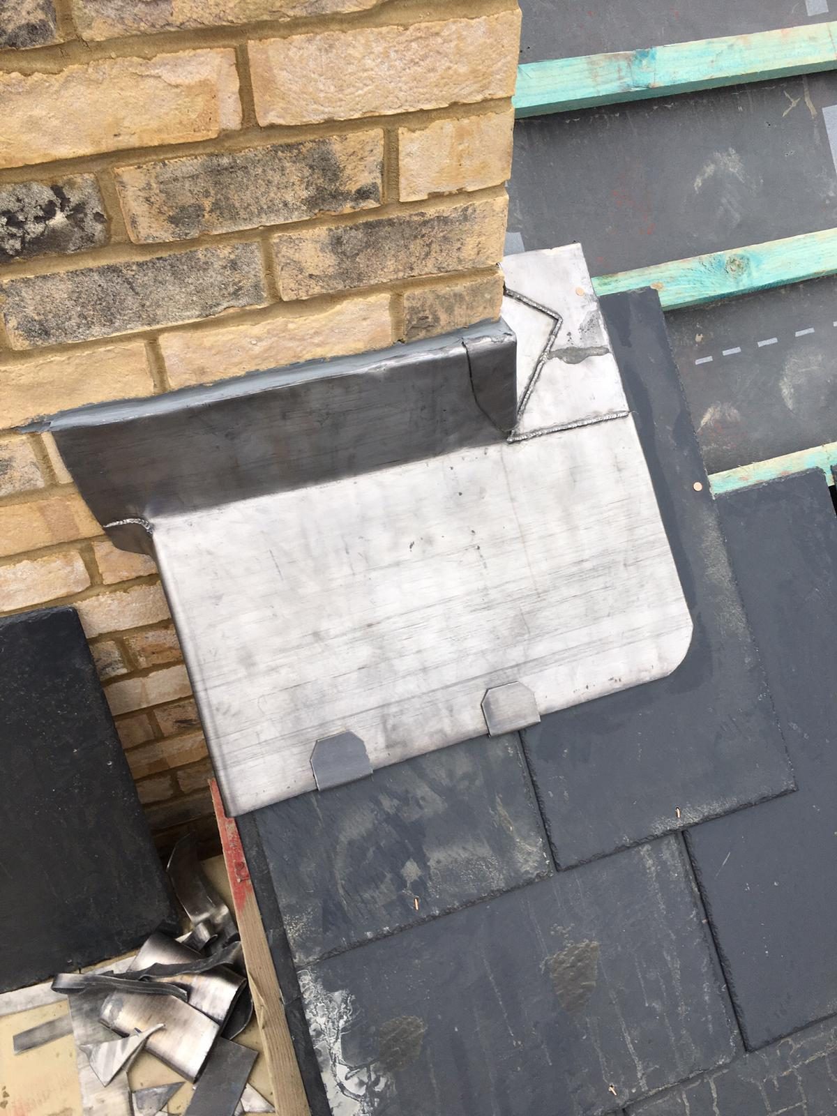 Completed - The completed roof showing detailed lead flashing fitted around the base of the brick chimney