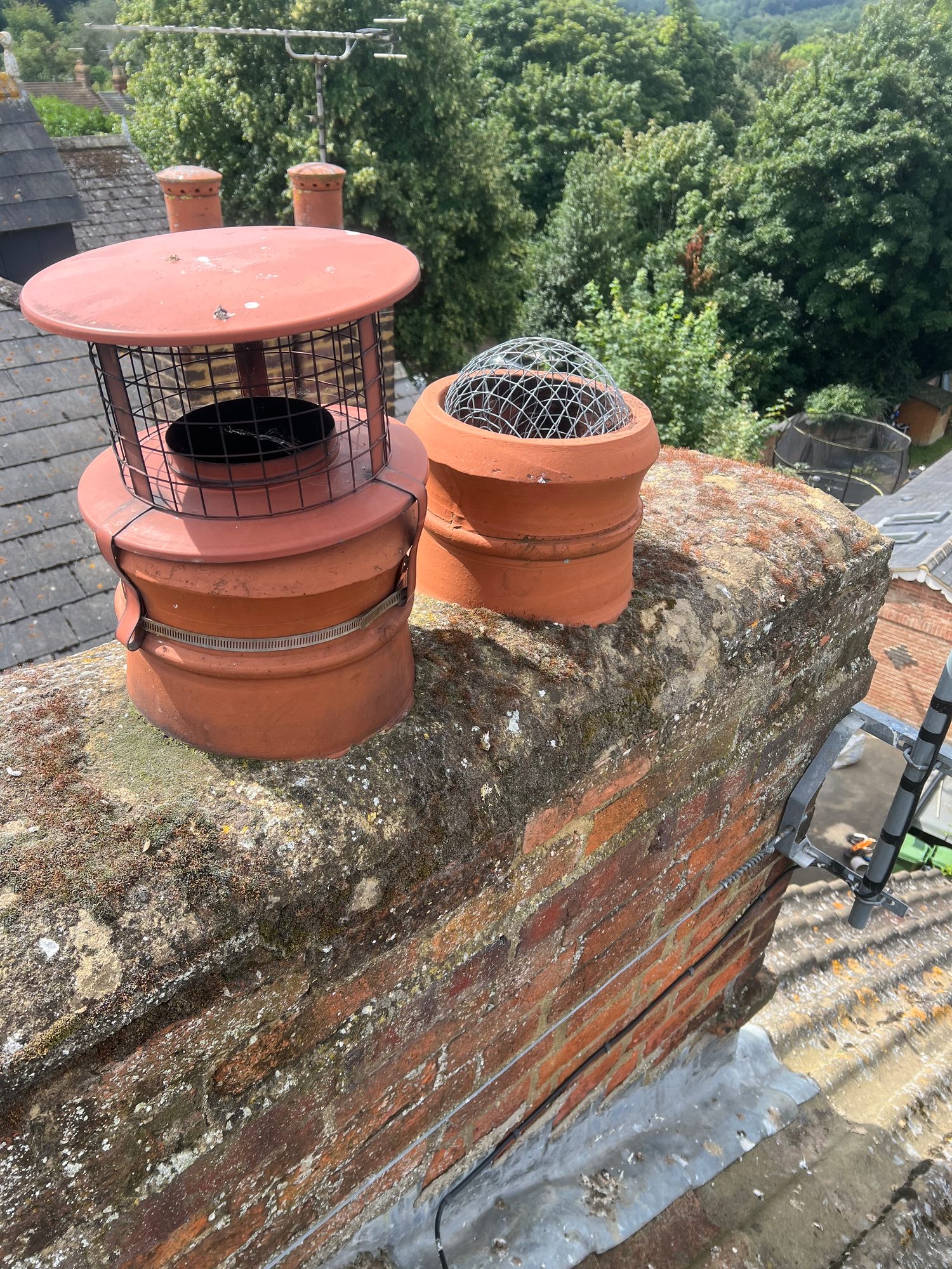 Before - The completed chimney with terracotta pots, bird guards and protective cowl fittings installed on the roof ridge