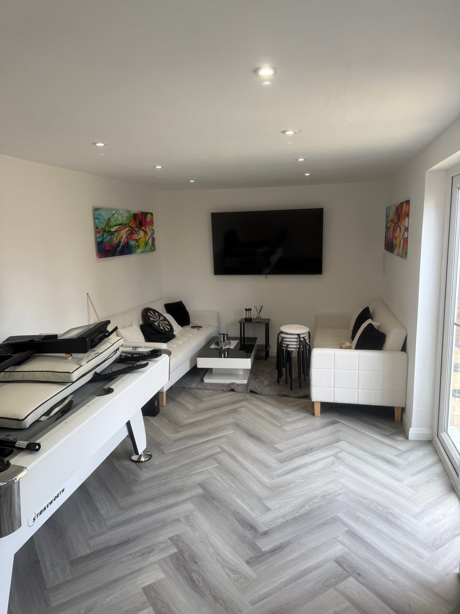 Completed conversion furnished as a combined living and entertainment room with glazed garden access