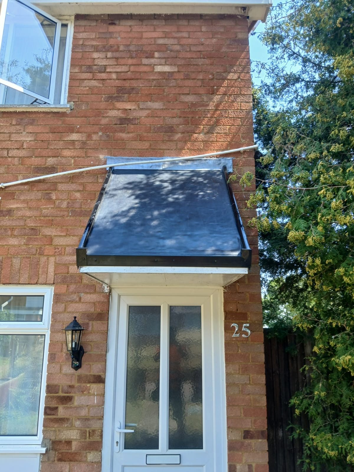 A smooth dark roof covering with metal edging and flashing